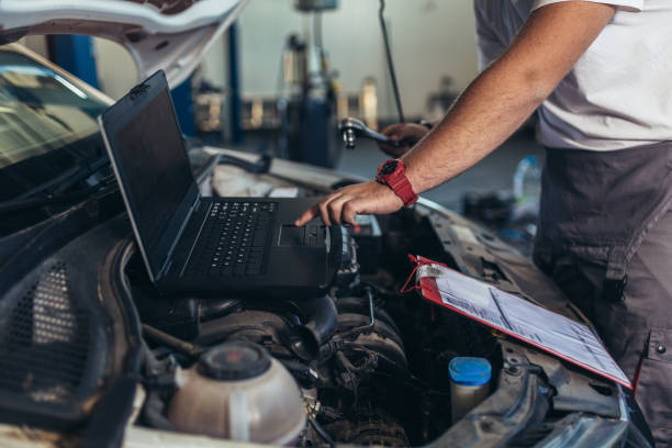 istock Professional car mechanic working in auto repair service using laptop. 1336627373