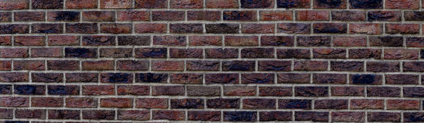 istock Panoramic background of wide old dark red brick wall texture. brown panoramic background 1336630509