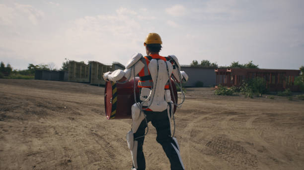 istock Man in exoskeleton carrying barrel on construction site 1336631367