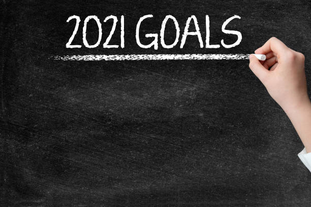 istock 2021 Goals on blackboard with woman hand 1336632898