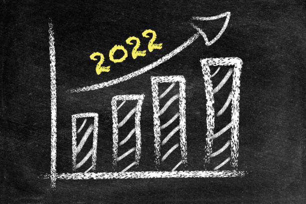 istock Year 2022, ascending arrow and bar graph on blackboard 1336634256