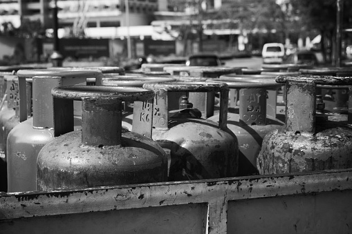 Household gas cylinders with propane stands in a row,  black and white photo