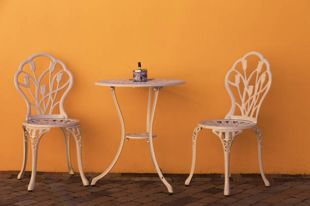 istock Table and two chairs against yellow wall outdoors 1336634859
