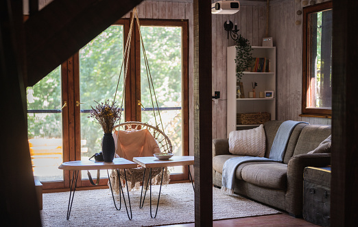 Cozy country house with a boho-style living room and a white-gray plank wall.