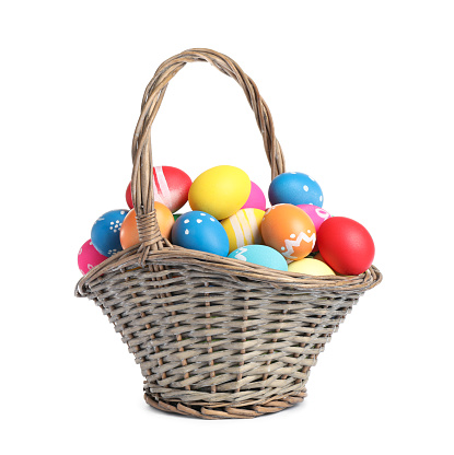 Basket with colorful Easter eggs isolated on white