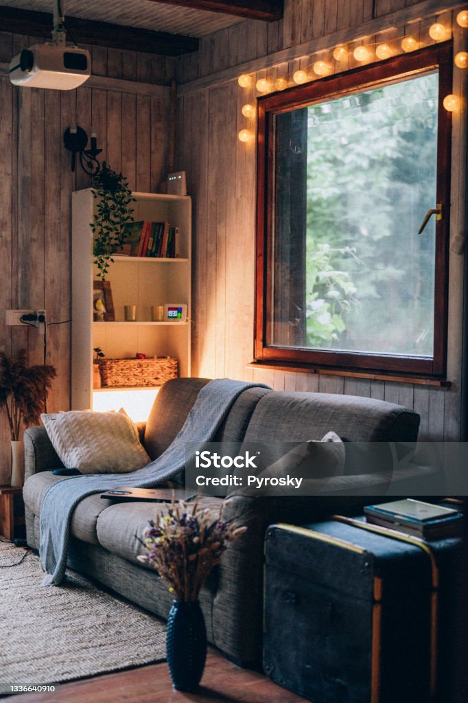 Cozy home interior background with video projector Cozy country house with a boho-style living room and a white-gray plank wall. Living Room Stock Photo