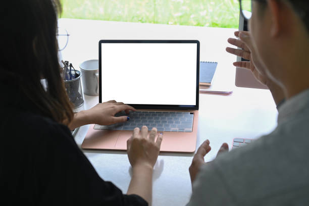istock Back view of two business colleagues working together with computer laptop. 1336641513