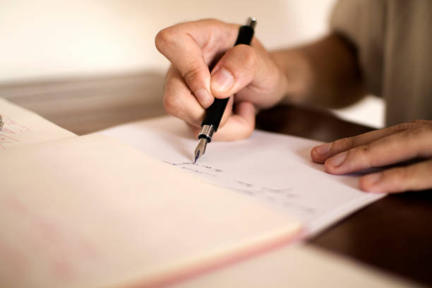 istock Man writing by hand with fountain pen 1336641935