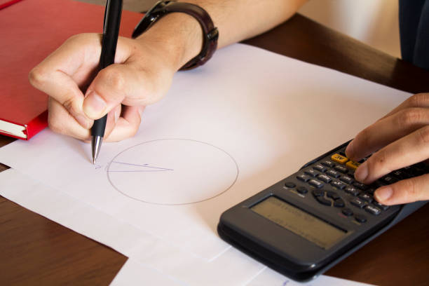 man working calculations at his desk - strategy plan architecture mathematical symbol imagens e fotografias de stock