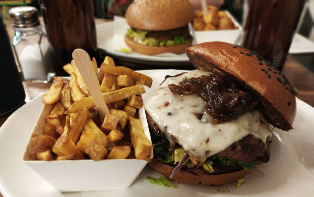 istock two hamburgers with onion, lettuce, cheese and potatoes 1336642841