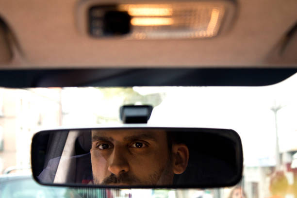 istock man looking in the rear view mirror of the car 1336643077