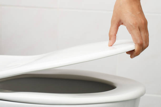 istock man's hand opening the toilet lid 1336644056
