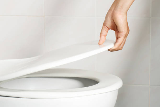 istock man's hand opening the toilet lid 1336644057