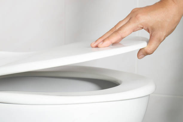 istock man's hand opening the toilet lid 1336644071