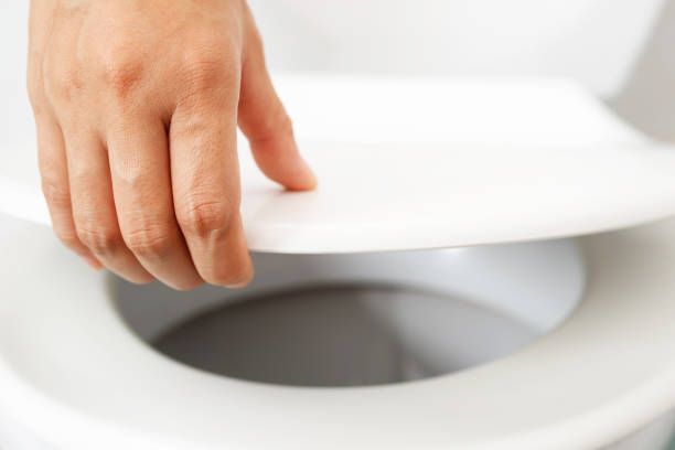 istock man's hand opening the toilet lid 1336644110