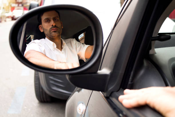 istock man inside the car with his reflection in the external rear view mirror 1336644805