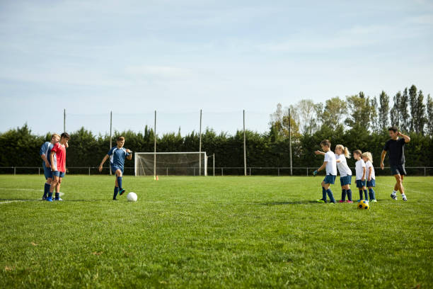 istock Coach teaching soccer to children at field 1336646229