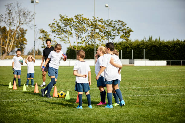istock Coach training kids in sports field 1336646825