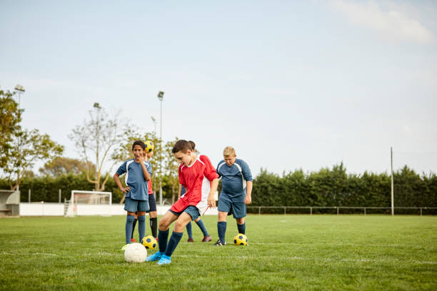 istock Teenager practicing soccer with team in field 1336646852