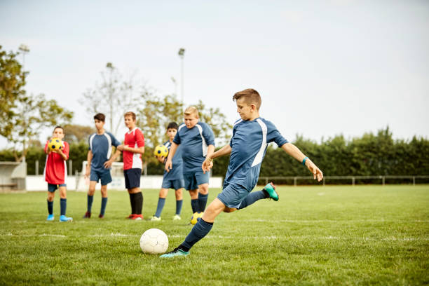 istock Teenager practicing soccer with team in playing field 1336646866