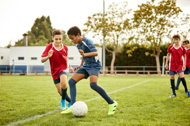 adolescentes praticando futebol em campo esportivo - soccer teenager sport adolescence - fotografias e filmes do acervo
