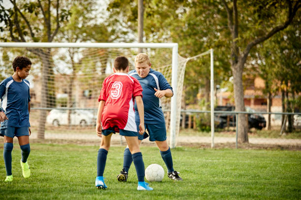 istock Teenage boys in uniform practicing soccer at field 1336646892