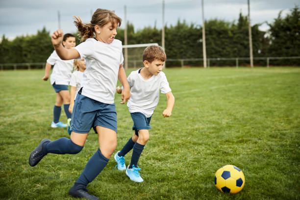 istock Children practicing soccer in field 1336647088