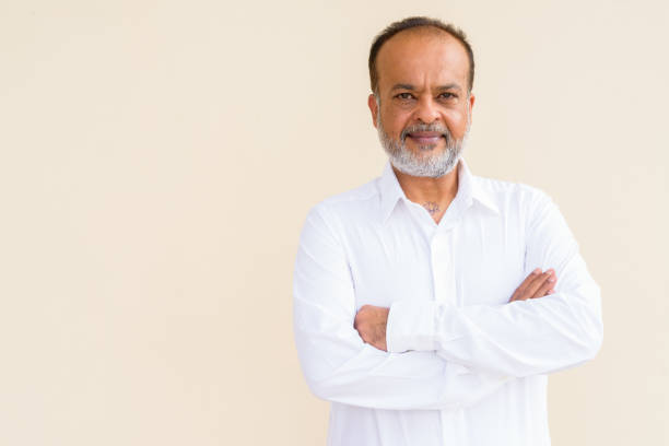 istock Portrait of handsome bearded Indian man against plain wall 1336647104