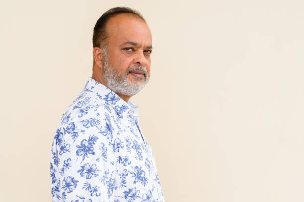 istock Portrait of handsome bearded Indian man against plain wall 1336647529