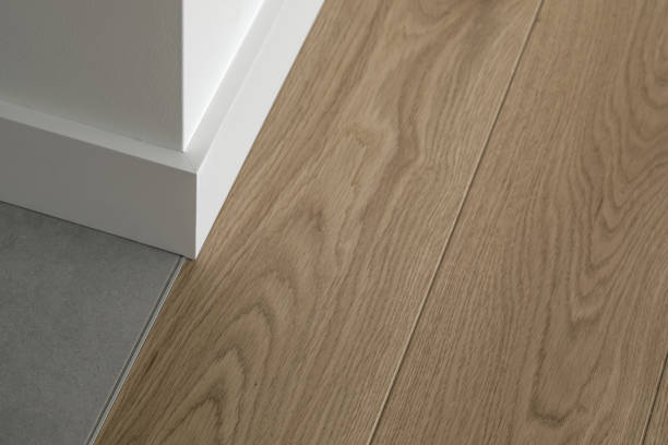 istock Room corner, three different textures: white wall, natural oak wood floor, stone grey tiles 1336647719