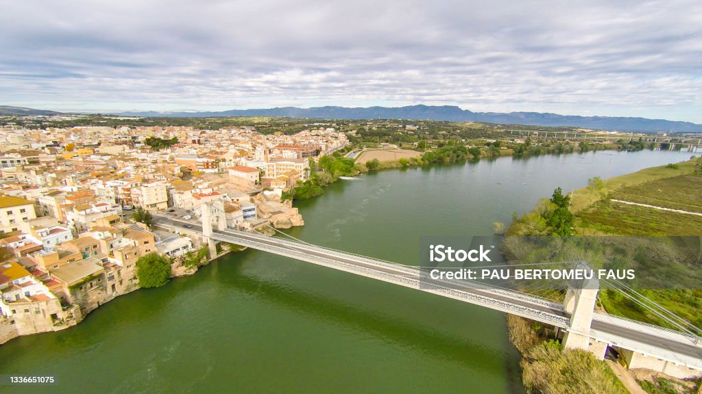 エブロ川のほとりに吊り橋を架けたスペインのタラゴナに位置するアンポスタ市の空中写真 エブロデルタのストックフォトや画像を多数ご用意 エ