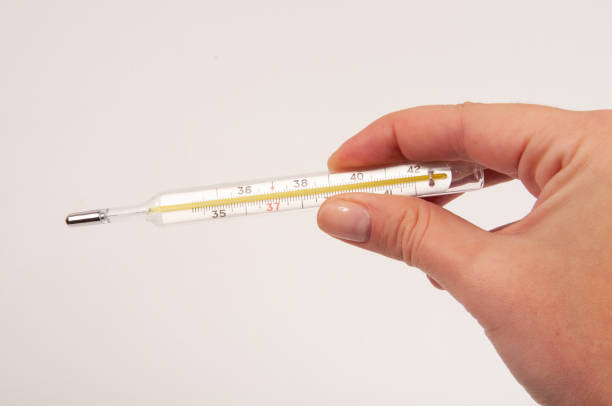 istock Medcine glass thermometer in hand on white 1336654256