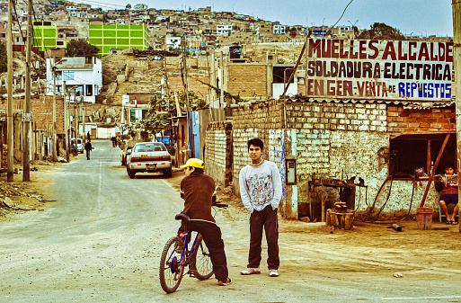Lima, Peru - August 13 2010 : two people are walking in a peruvian  shanty town on a dirt road