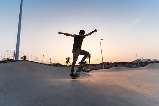 Young man skateboarding at sunset
