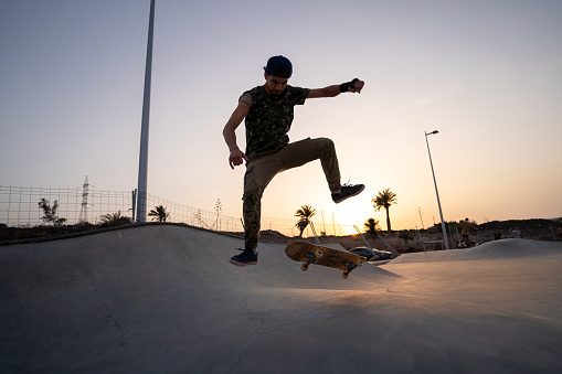 Young man skateboarding at sunset