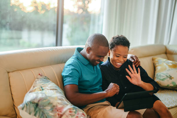 istock Cropped shot of an affectionate young couple video chatting on a tablet while sitting on their living room sofa at home 1336656855