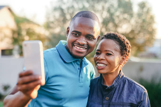 istock Cropped shot of an affectionate young couple taking selfies while standing in the backyard at home 1336656896