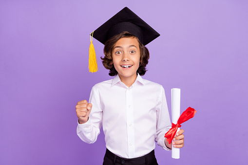 Photo of funny small brunet boy hold paper wear formalwear cap isolated on purple color background
