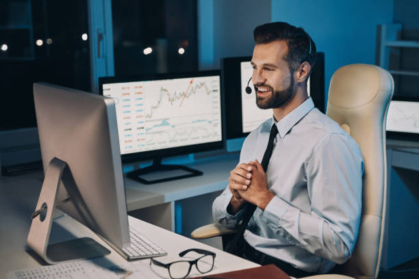 istock Happy young businessman in headset looking at the computer and smiling 1336658461
