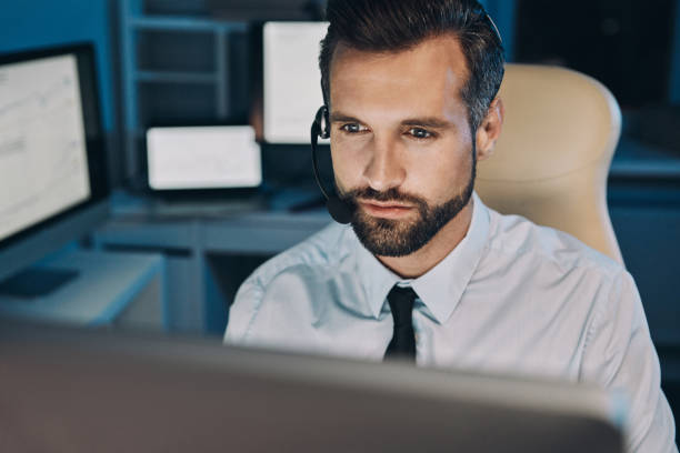 istock Confident young man in headset looking at the computer 1336658476