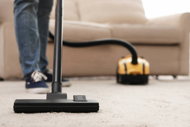 istock Young man using vacuum cleaner at home, closeup 1336662676