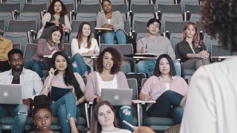 Attentive college class listening to female professor