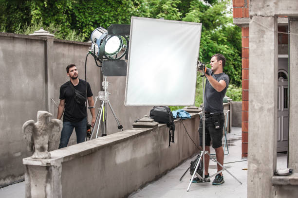 istock Behind the scene. Filmmaking lighting technician adjusting and setup lights 1336668600