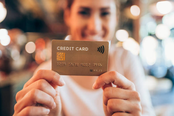 istock Woman holding a credit card. 1336668939