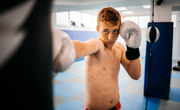 istock Concentrated young sporty man boxing with punching bag 1336669238