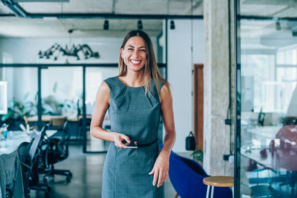 istock Happy businesswoman using phone in modern office. 1336669439