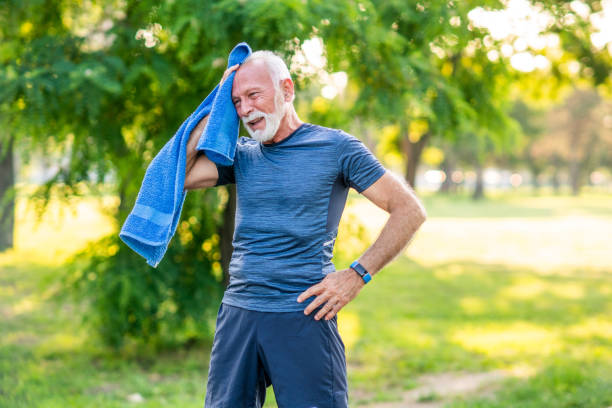 älterer mann, der nach dem training im park eine pause einlegen kann. - warm clothing stock-fotos und bilder