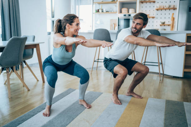 pareja haciendo ejercicio juntos en casa. - stretching boyfriend indoors lifestyles fotografías e imágenes de stock