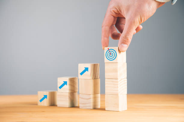 istock man holding goals with idea on wooden cubes 1336672516