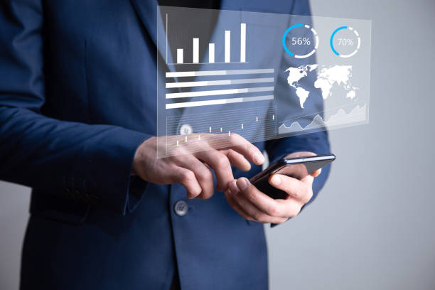 istock man holding phone with finance icons 1336672520
